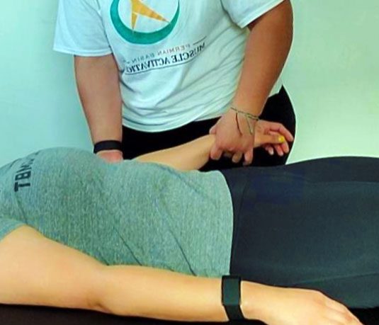 Muscle activation session on a client, post-injury and pre-surgery care in Midland, TX